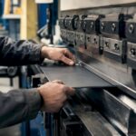 Hands adjusting sheet metal bend in workshop