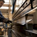 Vue rapprochée d’une tôle métallique en cours de pliage dans un atelier