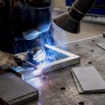 Soudeur en plein travail sur de l’acier galvanisé dans un atelier.