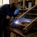 Metalworker welding stair stringer in workshop