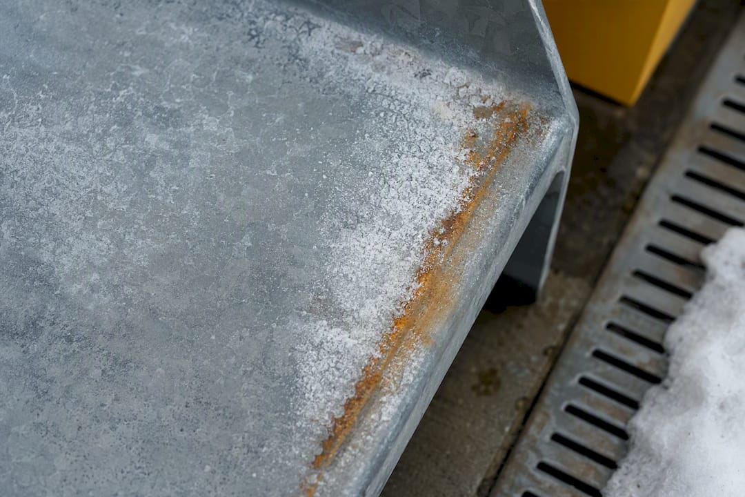 White zinc oxidation beside rust on galvanized steel