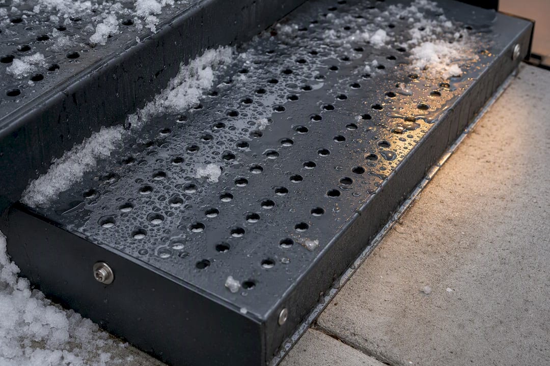 Perforated steel tread with melting snow