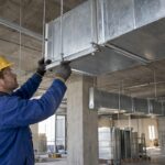 Installer checking suspended rectangular duct supports