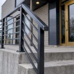 Exterior metal railing beside a concrete stair