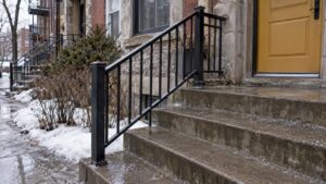 Steel railing beside wet Montreal duplex steps