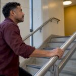 Man gripping a steel stair handrail