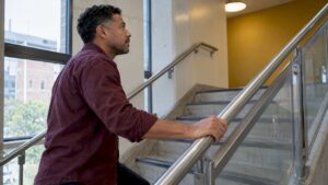 Man gripping a steel stair handrail