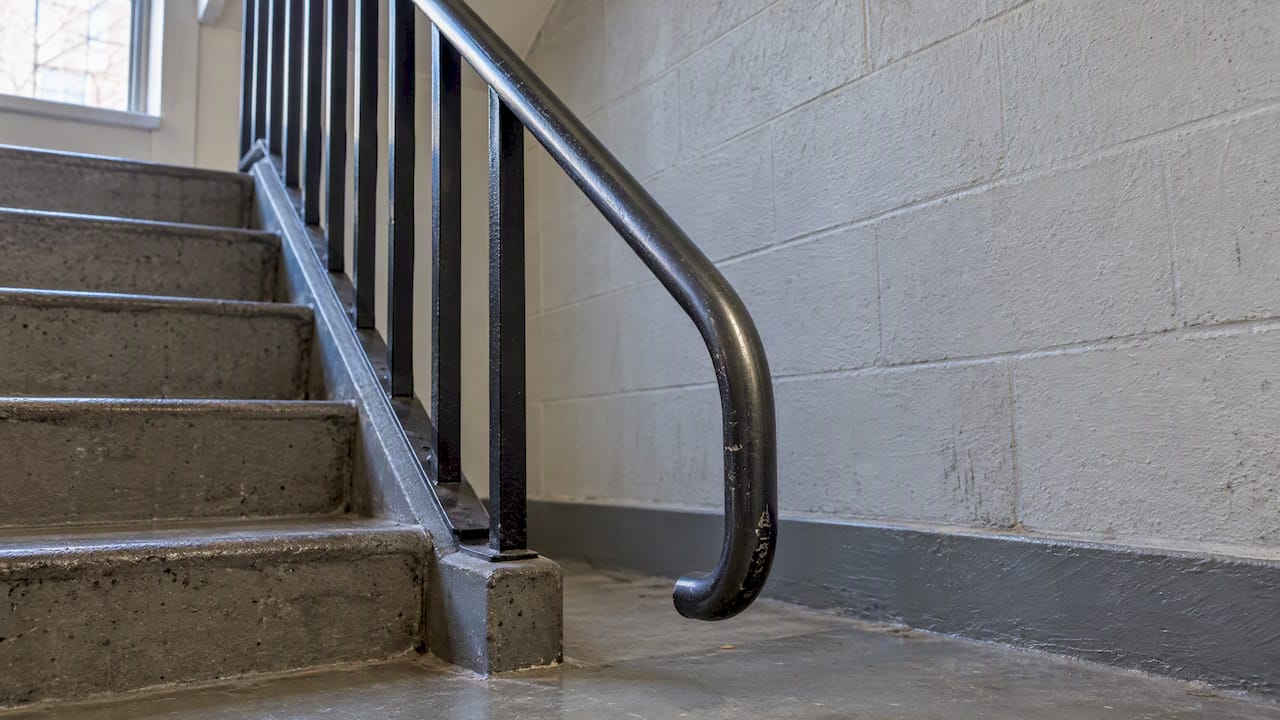 Steel handrail end returned toward floor